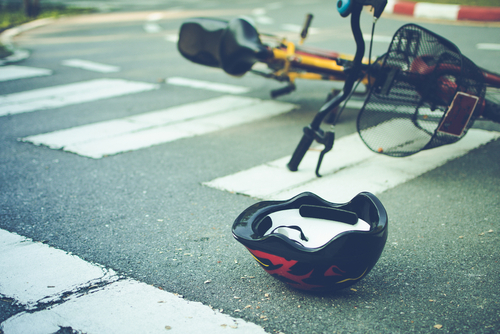 Bicycle and helmet on the road after a crash — Millington bicycle accident lawyer helping injured cyclists recover compensation.
