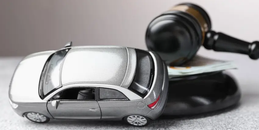 A silver toy car model and legal gavel are representing car accidents and litigation and personal injury claims at Mogy Law Firm in Tennessee.