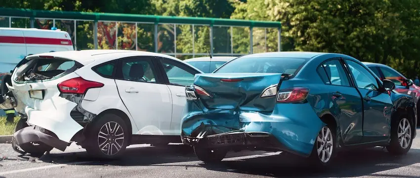 Two vehicles (a white and turquoise car) are involved in a rear-end collision chain reaction and is showing common car accidents in neighborhoods within Tennessee.