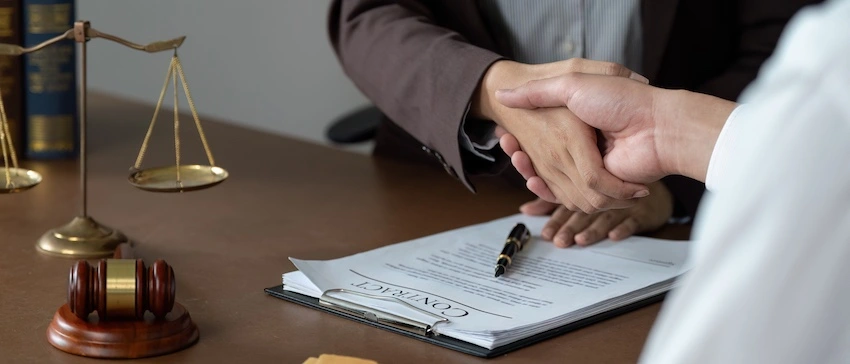 A Memphis rideshare accident lawyer is shaking hands with a female client.