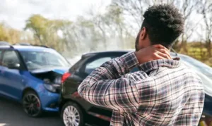 Man holding his neck after a car crash, highlighting the need for a personal injury lawyer.